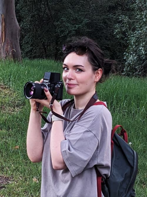 Eve holding a camera outdoors